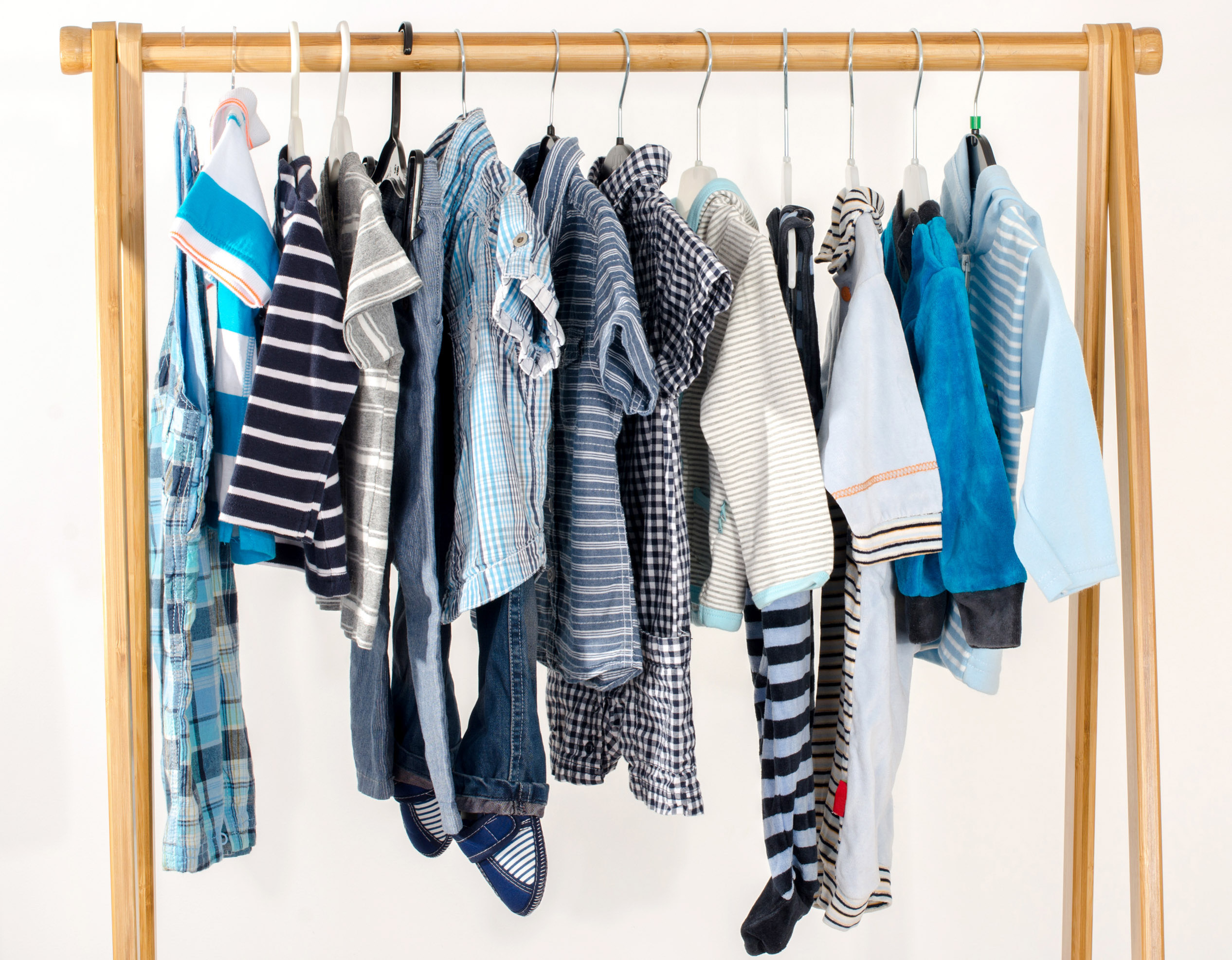 Dressing closet with clothes arranged on hangers.Blue and white wardrobe of newborn,kids, toddlers, babies full of all clothes.Many t-shirts,pants, shirts,blouses, onesie hanging