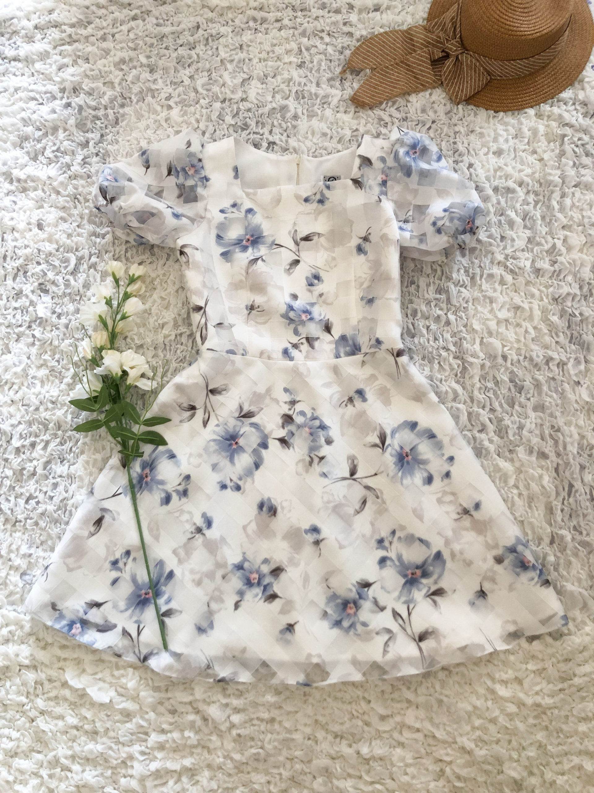 Purple floral dress laid flat on the floor women clothing top view vintage summer dress puff sleeve sundress online clothing store women dress in white background summer clothing catalog